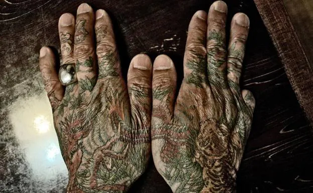 Un Yakuza muestra sus manos tatuadas. 