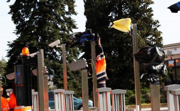 Operarios quitan las bolsas en las cámaras del peaje de la Ap-7 a la altura de La Roca del Vallès.