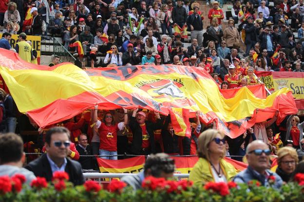 Los aficionados alzan una enorme bandera de España. 