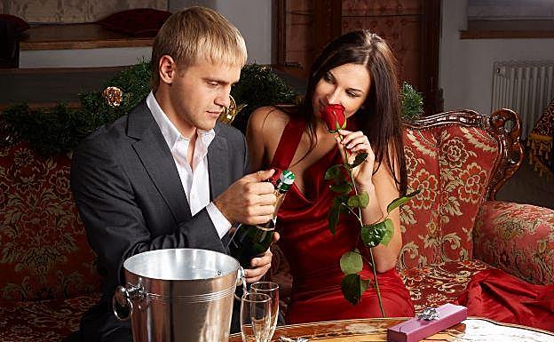 Pareja descorchando una botella.