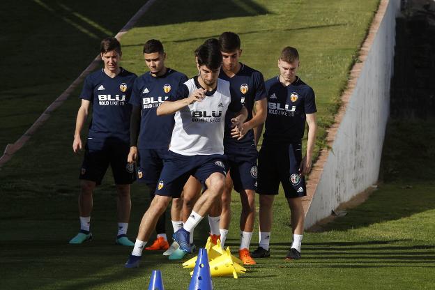 Carlos Soler salta un cono. 