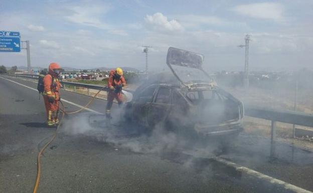 Bomberos trabajan en la extinción del incendio del coche en la A-7.