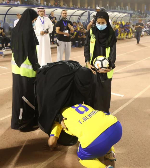 Al-Hurifi, el jugador homenajeado, es abrazado por una mujer con burka. 