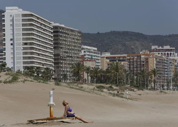 Una mujer toma el sol en una playa de Cullera. 