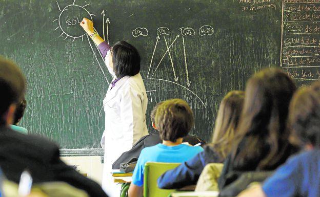 Una profesora explica en una clase.