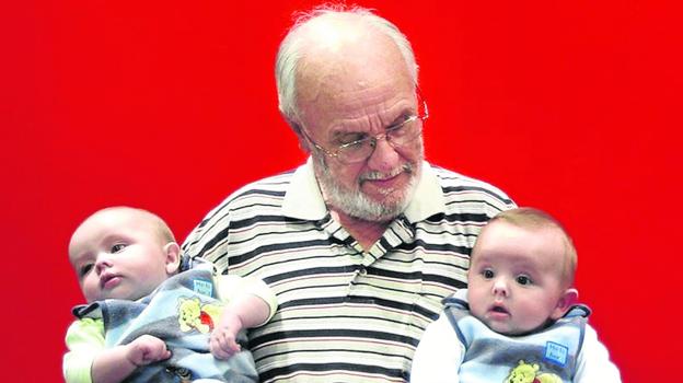 El australiano James Harrison, una leyenda nacional, posa con dos bebés en sus brazos. australia