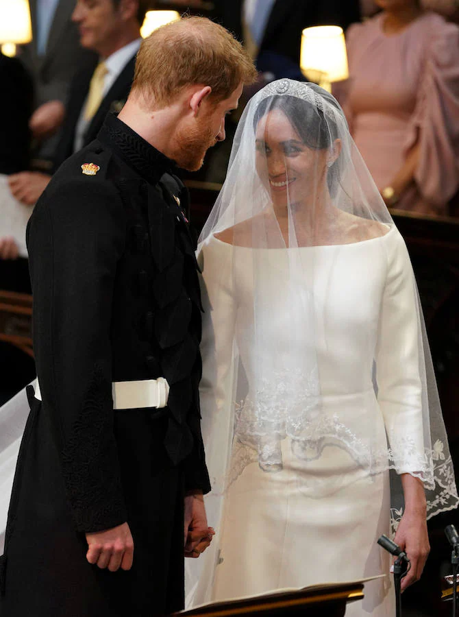 La estadounidense Meghan Markle escogió a la diseñadora británica Clare Waight Keller para su vestido de novia en la boda celebrada hoy en el castillo de Windsor con el príncipe Enrique. Markle lució un diseño muy sencillo, blanco inmaculado con escote de cuello de barco y cubrió su rostro con un velo transparente, adornado con bordados en los bordes hechos de organza y con una cola de cinco metros de longitud. La exactriz adornó su cabeza con una tiara de diamantes, prestada por la abuela del príncipe Enrique, la reina Isabel II.