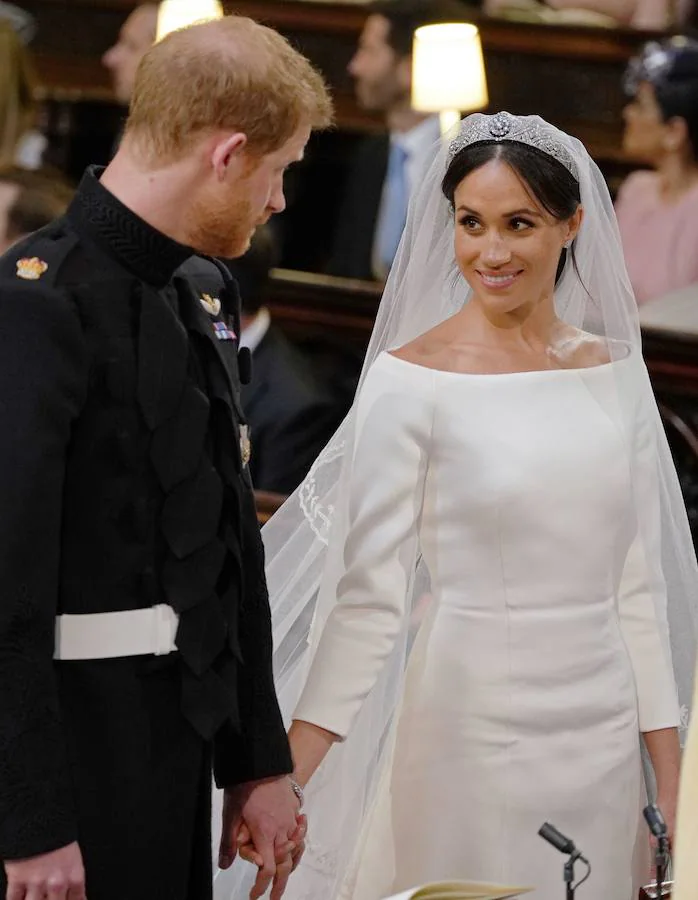 La estadounidense Meghan Markle escogió a la diseñadora británica Clare Waight Keller para su vestido de novia en la boda celebrada hoy en el castillo de Windsor con el príncipe Enrique. Markle lució un diseño muy sencillo, blanco inmaculado con escote de cuello de barco y cubrió su rostro con un velo transparente, adornado con bordados en los bordes hechos de organza y con una cola de cinco metros de longitud. La exactriz adornó su cabeza con una tiara de diamantes, prestada por la abuela del príncipe Enrique, la reina Isabel II.