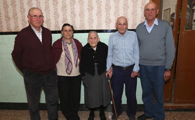 La pareja de centenarios, en el centro de la imagen, con sus tres hijos en su casa de La Yesa.