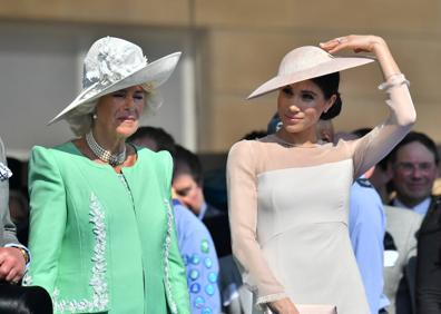 Imagen secundaria 1 - El príncipe Carlos, Camila, Meghan y Harry, este martes, en los jardines del Palacio de Buckingham. 