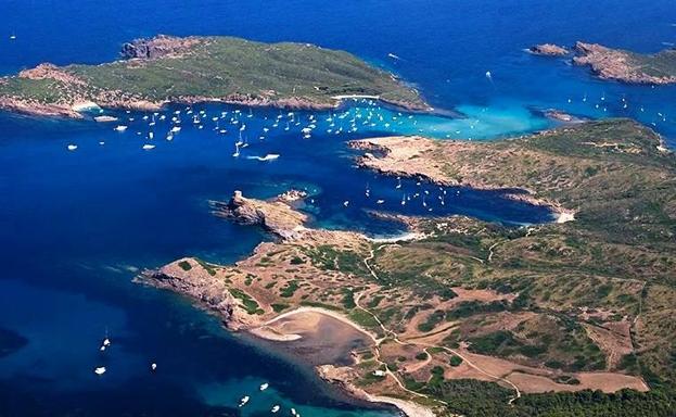 Vista desde las alturas, la isla de Colom se presenta como un destino de embarcaciones de recreo.