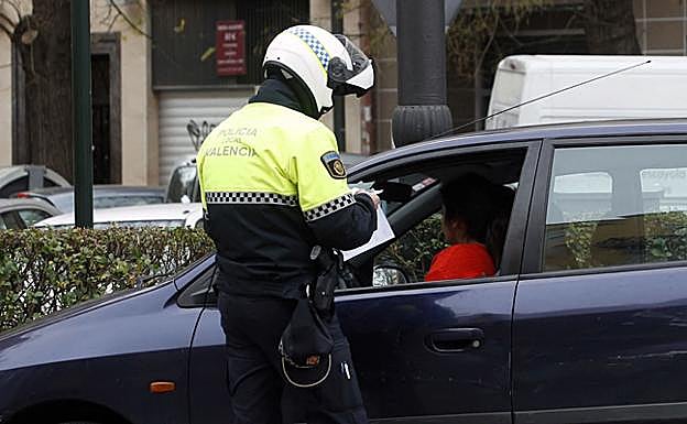 Un policía local de Valencia multa a una conductora.