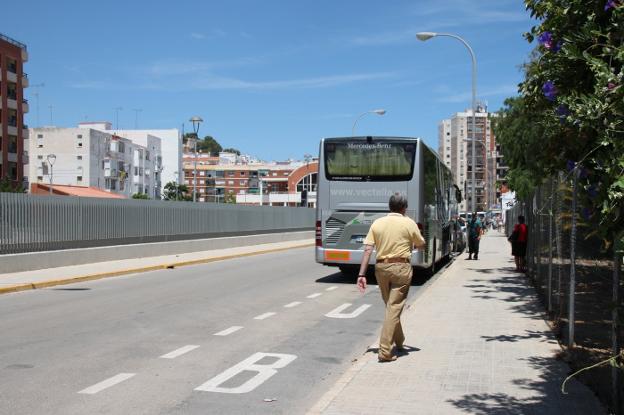 Varios pasajeros esperan el autobús en la nueva ubicación de la parada. 