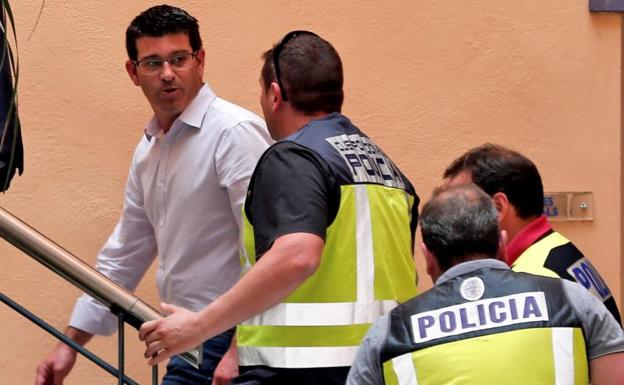 Jorge Rodríguez, detenido, es custodiado por los policías en el Ayuntamiento de Ontinyent. 