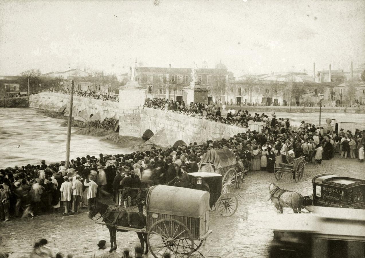 Multitud de personas contemplan en el puente de San José la crecida del río en 1897.