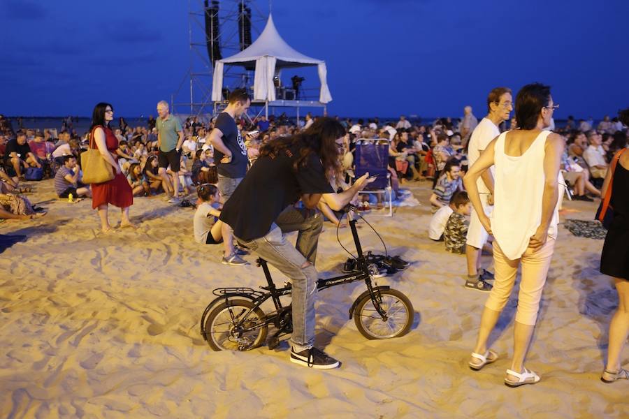 La Orquesta de Valencia hace historia junto al mar. Por primera vez, cierra la temporada en la playa de Las Arenas en un espectáculo para más de 1.000 personas. Un escenario de 300 metros y una cúpula transparente sirve de foco de atracción para el numeroso público congregado en la noche de este viernes en la playa. El concierto se ha bautizado con el nombre de 'Música i Aigua amb l'Orquesta de València'.