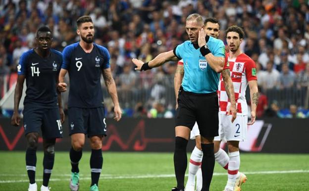 Néstor Pitana escucha a los colegiados del VAR momentos antes de pitar el penalti contra Croacia.