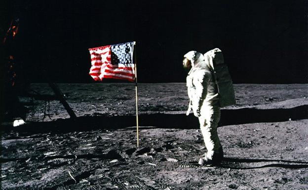 El astronauta Neil Armstrong, junto a una bandera estadounidense, en la superficie lunar.