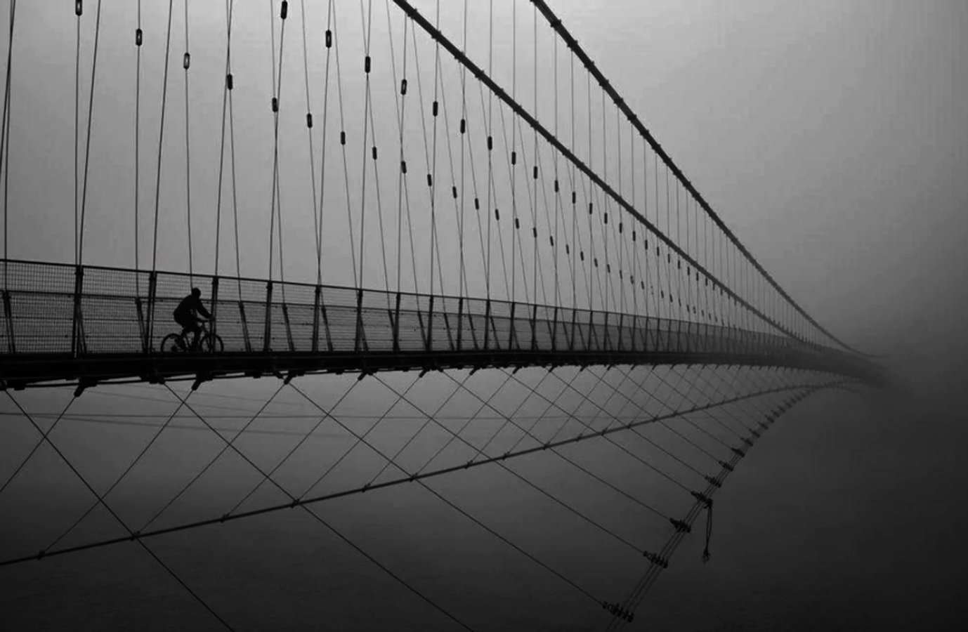 Un transeúnte atraviesa el puente de Ram Jhula en la India. "De repente vi a un hombre en bici que se dirigía hacia el puente. Por suerte, el puente estaba vacío. Encuadré el momento en mi mente y presioné el obturador para capturar la imagen", tomada en el instante perfecto, simulando que puente no tiene fin y creando en nuestras mentes un viaje del ciclista hacia el cielo.