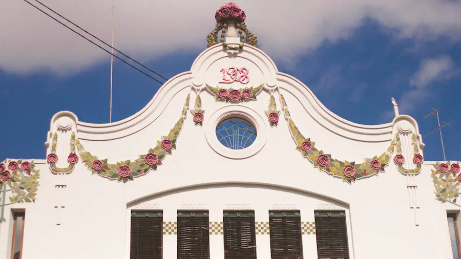 El edificio usa cerámica para la guirnalda superior y el manojo de rosas en el remate del hastial del chaflán.