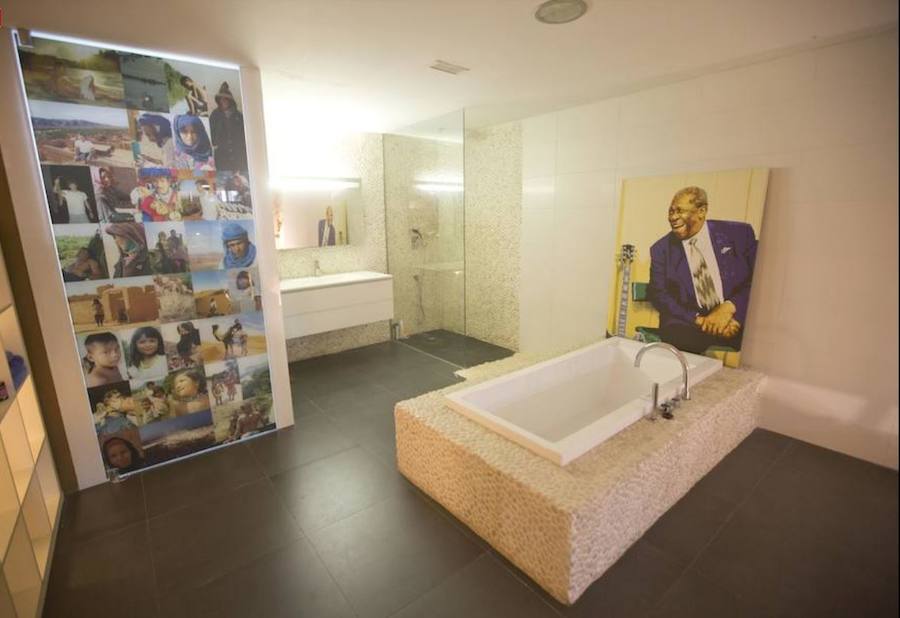 En el cuarto de baño abierto, que se erige junto a la zona de descanso, la bañera está forrada de piezas formadas por cantos rodados. El único espacio cerrado es la zona del inodoro, a la que ha dotado de privacidad con una puerta de cristal forrada con fotografías.