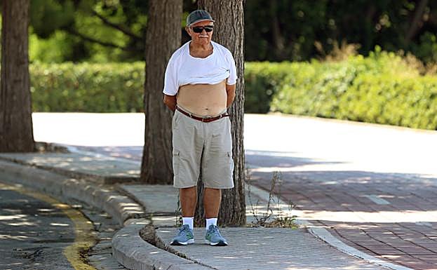 Un hombre trata de combatir el calor, a la sombra en Valencia.