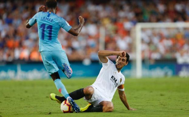 Parejo se lanza al suelo para arrebatar el balón a Lemar.