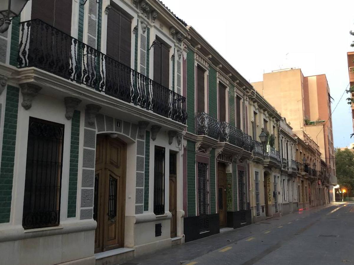 Es una de esas zonas poco conocidas de Valencia. El barrio de Campanar reúne todas esas características que se espera encontrar en un remoto y solitario pueblo, y no en plena urbe. Calles tranquilas, casas antiguas, fachadas con un encanto diseñado por el paso del tiempo. Recorrer sus aceras es pasear por un rincón de paz, ajeno al constante ajetreo de la ciudad. Una especie de paréntesis entre el tráfico, ruido y bullicio, en un lugar donde el reloj parece detenerse, mientras las sombras del atardecer se van colando por cada resquicio. Entre paredes blancas, tonalidades ocre, fuentes y ventanas que se asoman a décadas de historia, permanecen mosaicos en honor a lo que el pueblo fue. Azulejos que recuerdan al oficio hornero y la patrona, la Virgen de Campanar, cuelgan de paredes en las que los ladrillos soportan más años que peso. Casas, unas bajas y otras ilustres, que recuerdan un tiempo no tan lejano, muestras de la Valencia pasada rodeadas de la ciudad actual. 