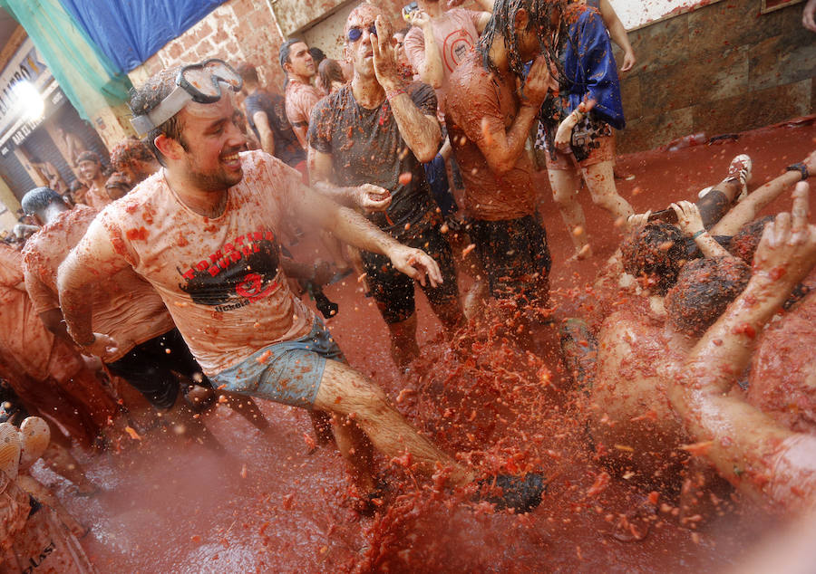 Buñol ha vivido este miércoles su fiesta más internacional. La Tomatina 2018 ha reunido a 20.000 personas que se han lanzado 145.000 kilos de tomate en la batalla menos cruenta de la historia. Ataviados con ropa vieja, gafas protectoras o chubasqueros, extranjeros y locales han disfrutado a tope de una fiesta que, además de diversión, genera un importante retorno económico a la localidad. 