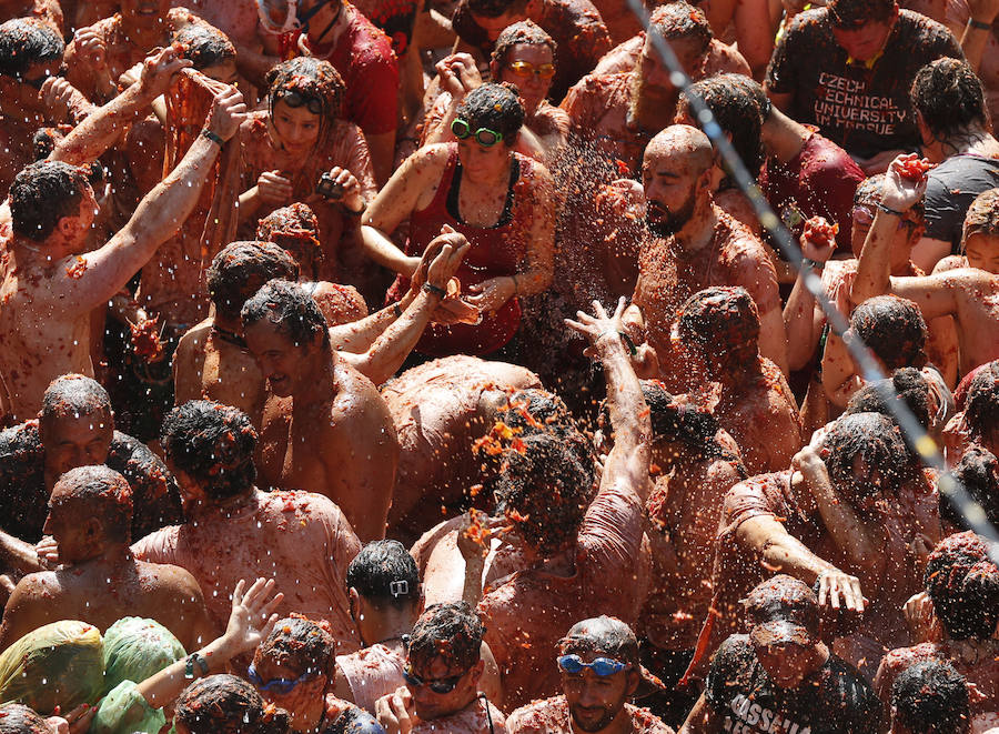 Buñol ha vivido este miércoles su fiesta más internacional. La Tomatina 2018 ha reunido a 20.000 personas que se han lanzado 145.000 kilos de tomate en la batalla menos cruenta de la historia. Ataviados con ropa vieja, gafas protectoras o chubasqueros, extranjeros y locales han disfrutado a tope de una fiesta que, además de diversión, genera un importante retorno económico a la localidad. 