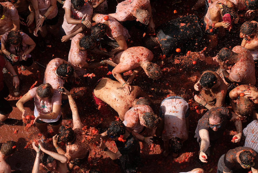 Buñol ha vivido este miércoles su fiesta más internacional. La Tomatina 2018 ha reunido a 20.000 personas que se han lanzado 145.000 kilos de tomate en la batalla menos cruenta de la historia. Ataviados con ropa vieja, gafas protectoras o chubasqueros, extranjeros y locales han disfrutado a tope de una fiesta que, además de diversión, genera un importante retorno económico a la localidad. 