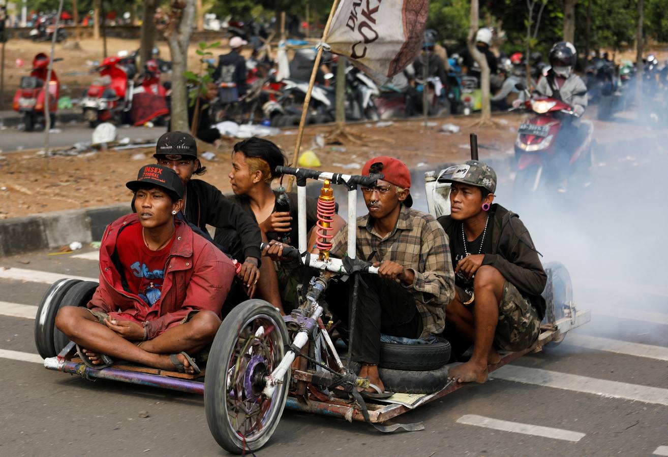 La Vespa convertida en 'monster-bike' al estilo 'Mad Max'. Cada año, desde adolescentes hasta abuelos indonesios se reúnen en la isla de Java para celebrar su pasión por el icónico 'scooter' italiano. Para algunos, es una especie de amor extremo, en el que los vehículos se personalizan o tunean para ver motos-monstruo sacadas de una distopía de Hollywood o una sociedad postapocalíptica. Cientos de entusiastas viajan al festival en Kediri y presumen de sus creaciones, desde Vespas antiguas restauradas hasta tanques de 'Mad Max' equipados con ametralladoras falsas, una docena de neumáticos adicionales o peluches de adorno.