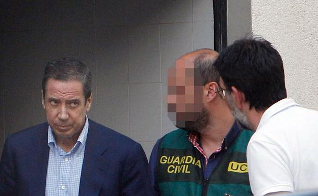 Zaplana, durante un registro tras su detención.