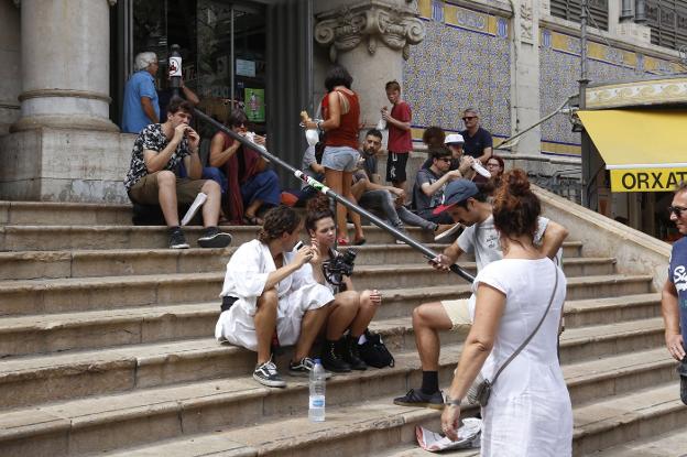 Turistas en la escalinata de acceso al Mercado Central de Valencia. 