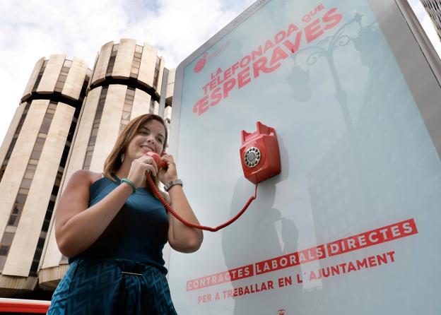 La portavoz socialista, Sandra Gómez, con el teléfono del panel publicitario. 
