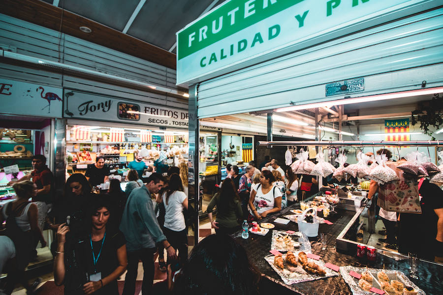 Numerosos valencianos y turistas abarrotan los mercados municipales de Valencia en la noche gastronómica y cultural programada este sábado en catorce recintos de la ciudad, el plato estrella del III Bonic/a Fest, que arrancó a las ocho de la tarde y se prolongará hasta la medianoche. La Fiesta de los Mercados Municipales, que persigue potenciar el comercio de proximidad y la alimentación saludable a través de los productos que se ofrecen en estos recintos, arrancó con colas a las puertas del Mercado Central, como en Ruzafa o el Cabanyal. 