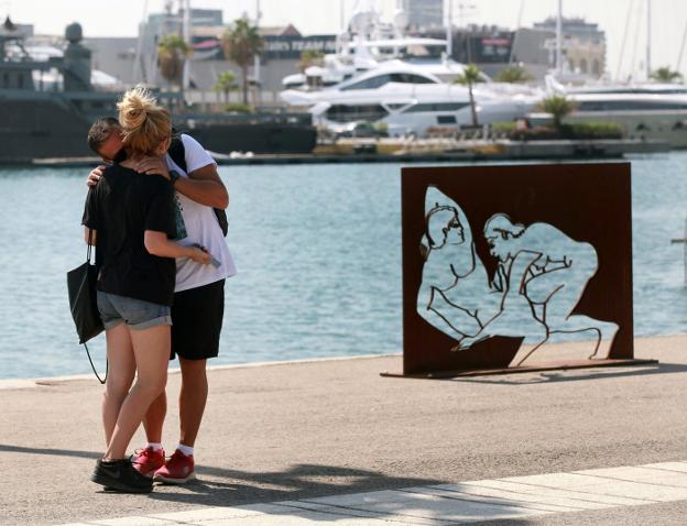 Una pareja se besa frente a una de las esculturas de la Marina, ayer por la tarde. 