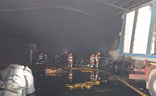 Los bomberos tratan de apagar el fuego en la nave. 