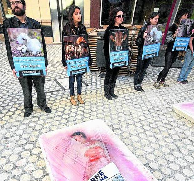 Impactante protesta del grupo Igualdad Animal en Málaga en la que un miembro simula ser carne humana a la venta.