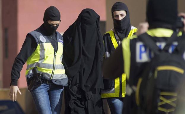 Policías trasladan a una detenida por yihadismo en España.