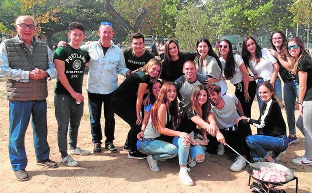 El alcalde con un grupo de jóvenes en las paellas. 