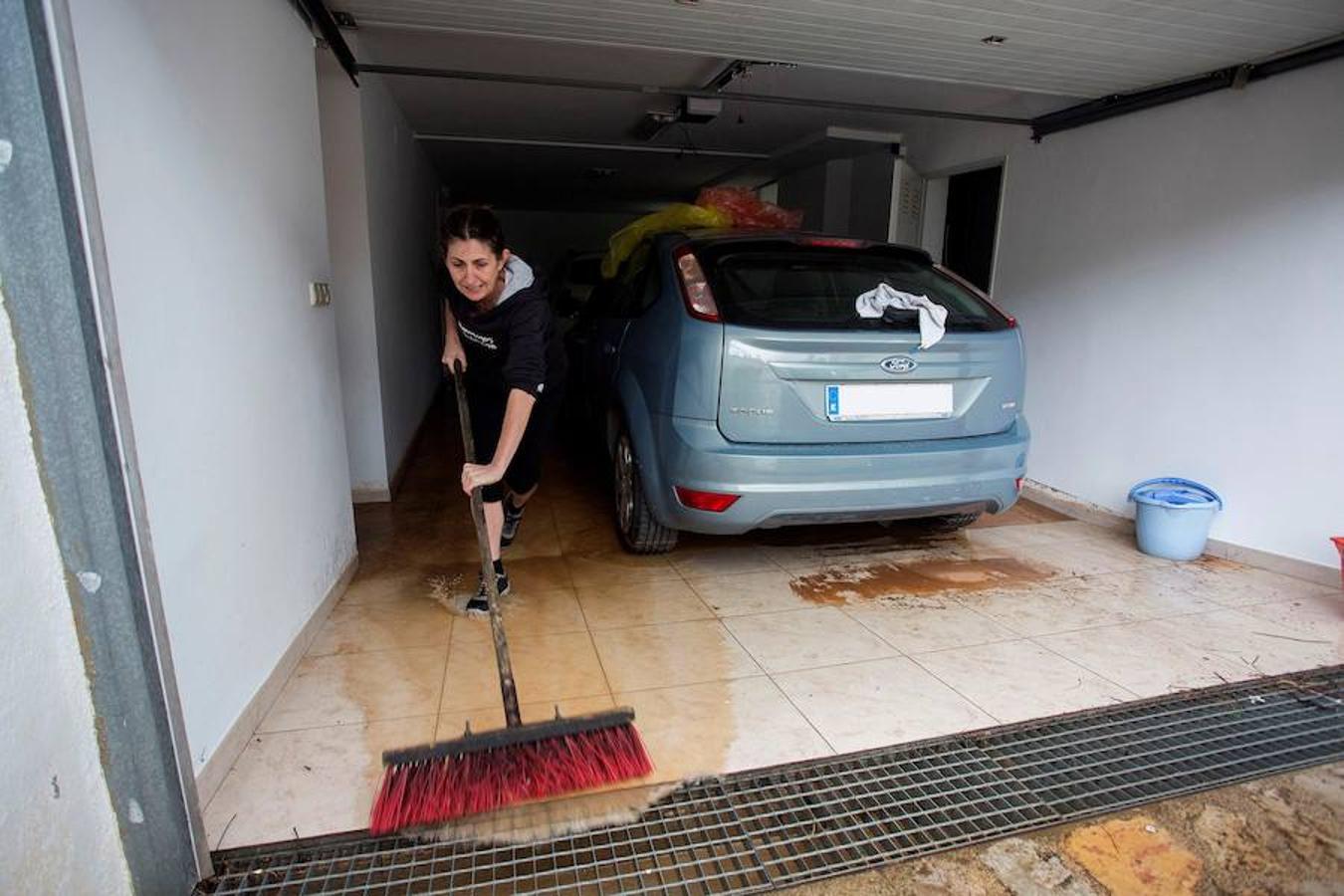 Una familia limpiando los detrozos en su casa en Castellón.