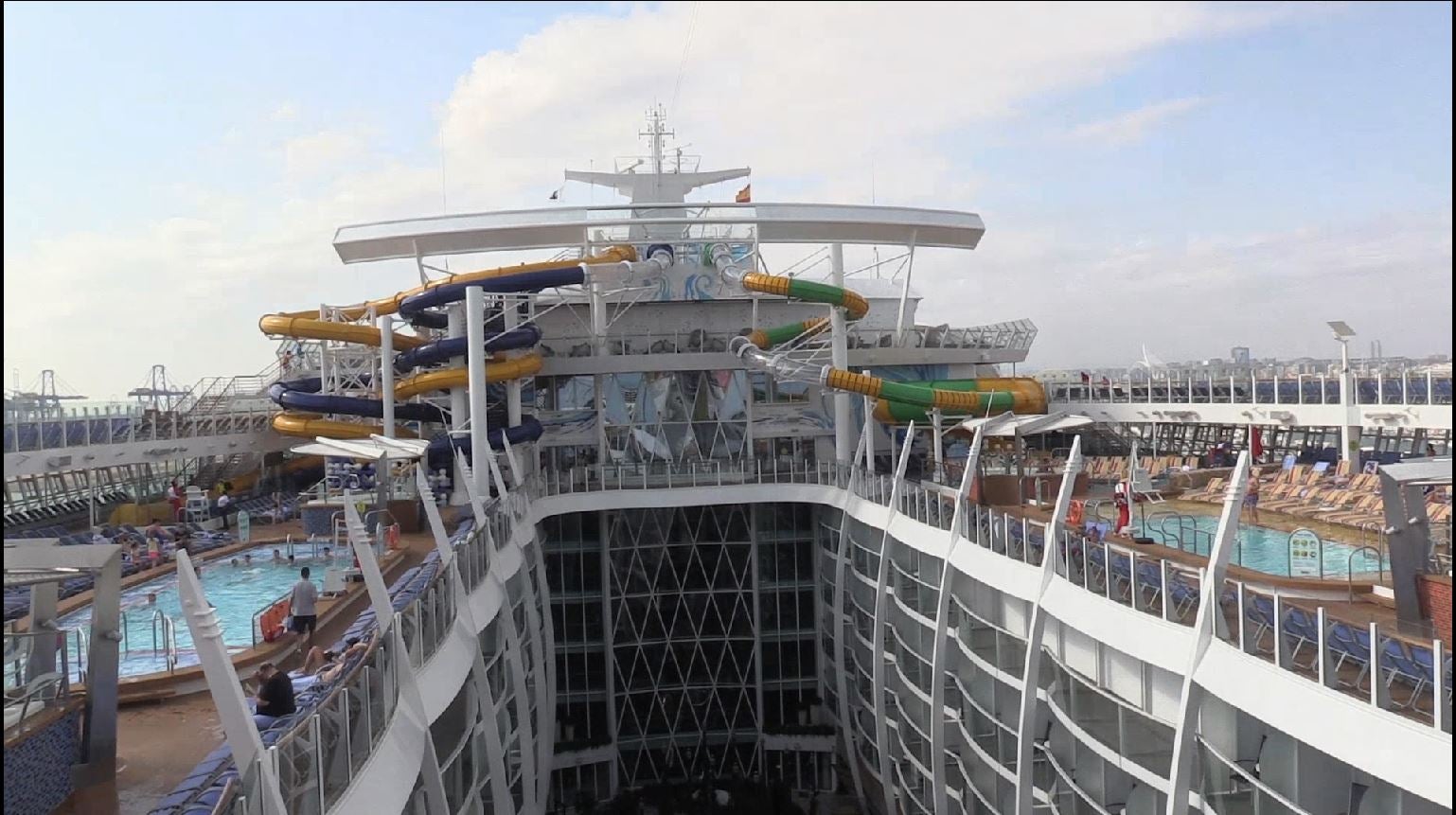 El 'Symphony of the Seas' ha hecho este domingo escala en Valencia en su periplo por el Mediterráneo. El Symphony es actualmente el mayor crucero del mundo. Sus cifras son de infarto: 362 metros de eslora, 226.000 toneladas de peso. El buque, de la compañía Royal Caribbean es una maravilla de la ingeniería: tiene 18 cubiertas y 19 piscinas. Además, dispone de 10 jacuzzis y 24 ascensores al servicio de más de 6.000 pasajeros alojados en 2.775 camarotes y atendidos por 2.200 miembros de la tripulación. The Ultimate Abyss, en la parte más elevada de la popa, es el tobogán más alto en el mar. Consta de dos toboganes serpenteantes que descienden desde una altura de diez plantas, 28 metros de caída que se recorren en menos de 15 segundos. Symphony of the Seas dispone de pista de running, un bar móvil que va elevándose o descendiendo como si de un ascensor se tratara, dos simuladores de surf, una tirolina de 25 metros de largo, camarotes con mayordomo y otra infinidad de lujos. Tras recorrer todo el Mediterráneo viajará al Caribe como próximo destino. 