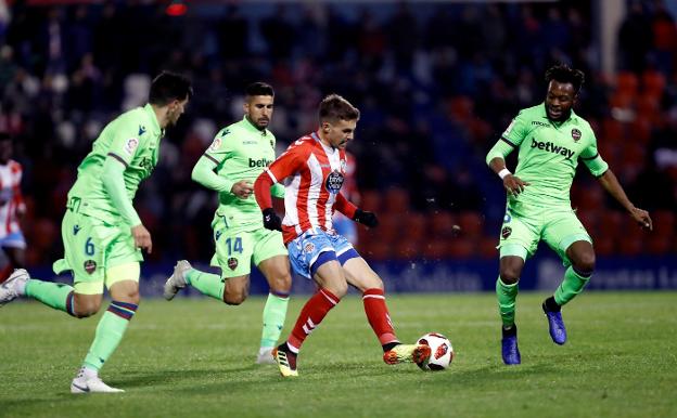 Juan Muñiz conduce el balón entre Chema, Samu García y Doukouré. 