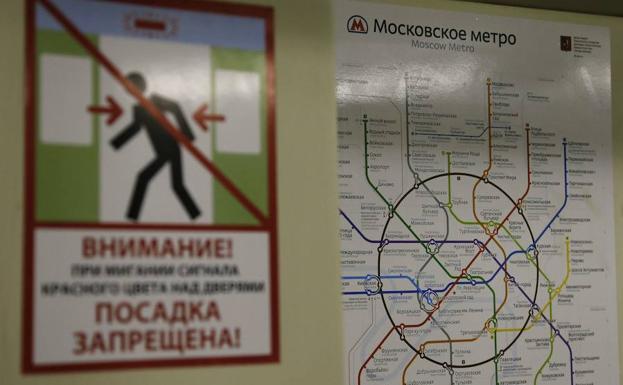 Vista de un cartel de seguridad junto a un plano del metro de Moscú. 