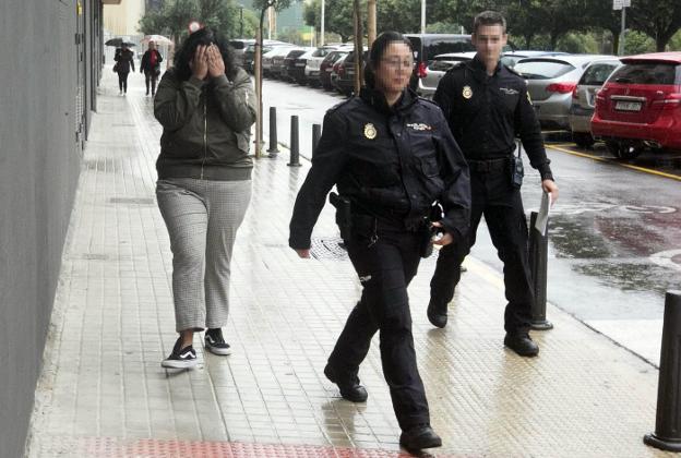 La estafadora Beatriz M. se tapa la cara con sus manos a la salida del juzgado de Mislata. 