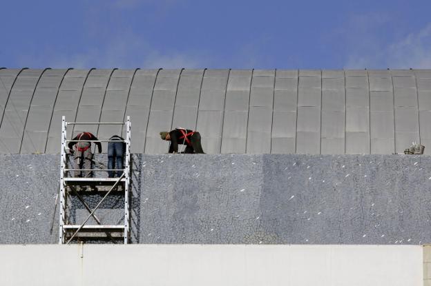 Tres operarios trabajan en la cubierta del Palau de la Música, ayer. 