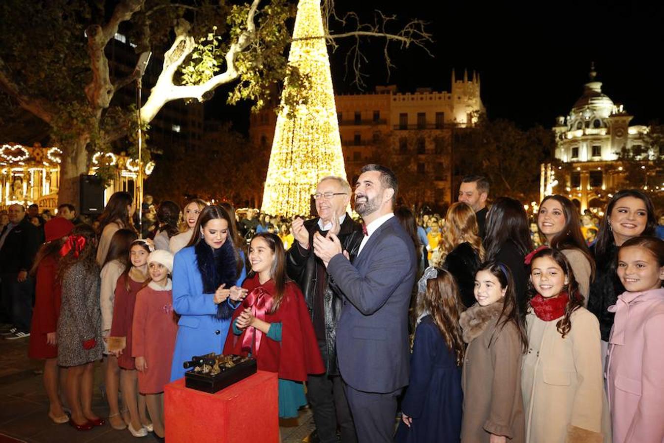 La Plaza del Ayuntamiento de Valencia ha vivido este viernes el encendido oficial de la iluminación navideña. Como gran novedad, este año otros dos barrios y dos pueblos de la ciudad se suman en la apuesta por descentralizar la decoración. Los dos barrios que este año estrenarán árbol de Navidad serán Benicalap y Malilla, sumándose así a las plazas de Patraix, Campanar, Benimaclet, Sant Valer (en Russafa), la Creu del Canyamelar y Doctor Collado (en Ciutat Vella), Orriols, Sant Marcel·lí y Abastos. Serán un total de 11 los árboles que se repartirán por toda la ciudad, además del de la Plaza del Ayuntamiento.