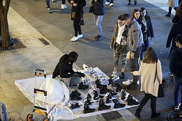Un vendedor ofrece sus productos de forma ilegal en el centro, ayer por la tarde. 