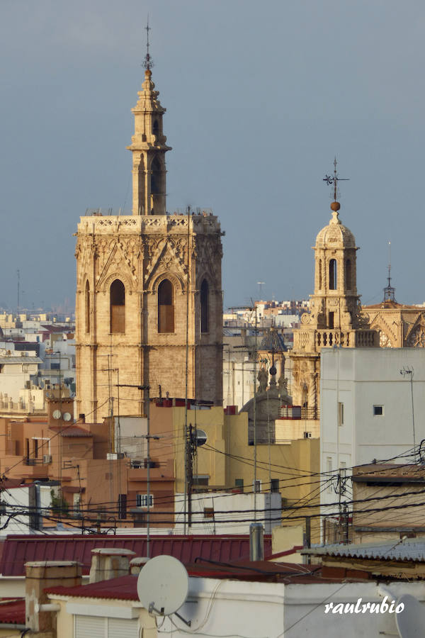 Valencia nunca deja de sorprender. Es habitual la imagen desde la calle de los múltiples campanarios que se encuentran en la ciudad. En el centro histórico aún encontramos más torreones eclesiásticos. Pero, ¿cómo se ve la ciudad desde el cobijo de las campanas?. Raúl Rubio, de la Associació de Mestres Campaners, ha inmortalizado esa visión de la que poca gente puede disfrutar: Valencia desde sus campanarios. Ver la plaza de San Agustín con una perspectiva diferente, contemplar el centro de la ciudad desde Santa Catalina, admirar Valencia desde las campanas del Real Monasterio de la Santísima Trinidad son algunos de las panorámicas exquisitas casi exclusivas para campaneros. La ciudad se redescubre desde las alturas, desde la perspectiva de gárgolas, campanas y tejados. Así es Valencia desde sus campanarios.